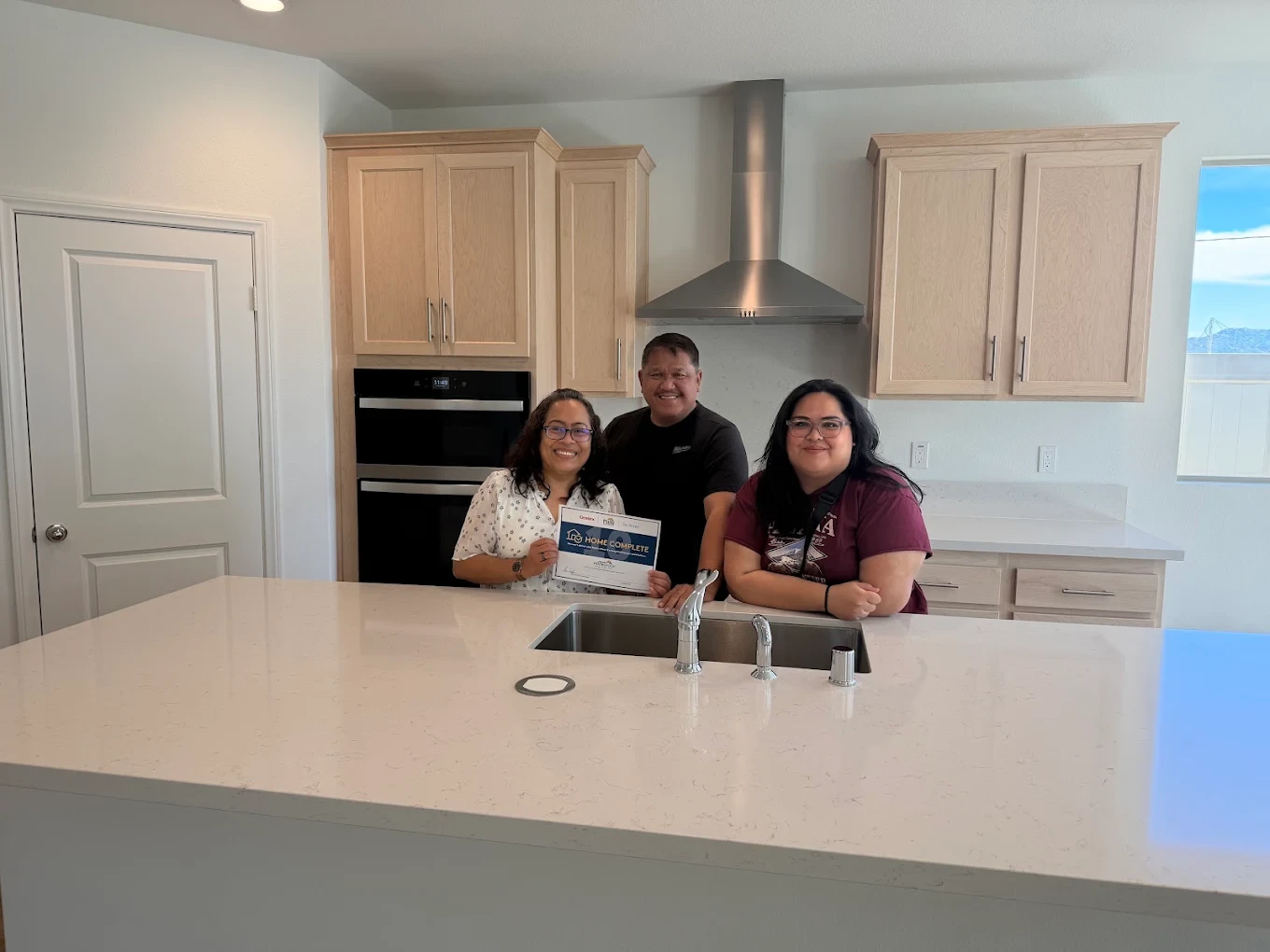 Filipino family celebrating home completion with certificate